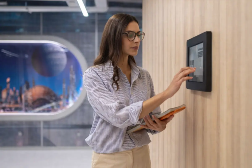 duvara monte dokunmatik akıllı ev otomasyon kontrol paneli kullanan kullanıcı